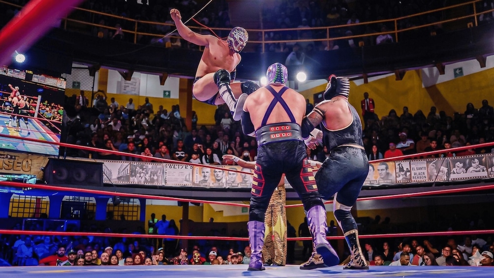 A wrestling match in a ring with an audience in the background. 4