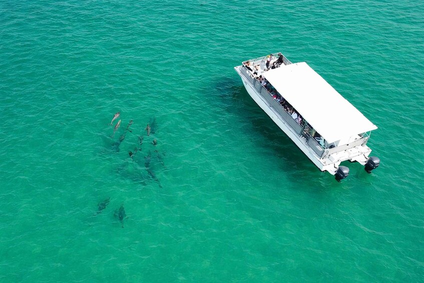 A boat with passengers on a turquoise sea. 1