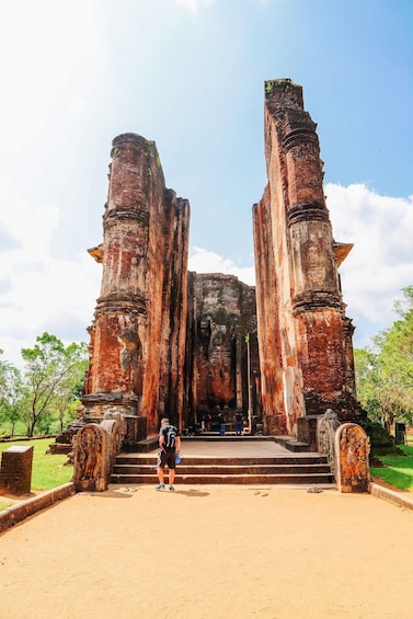 A large, ancient brick structure with a central doorway and steps leading up to it. 3
