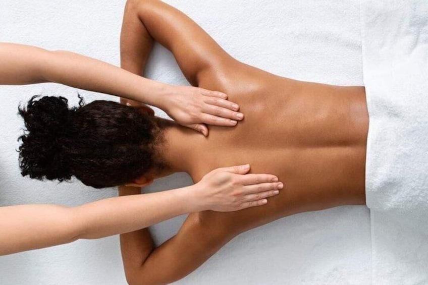 A person receiving a back massage on a white towel. 3