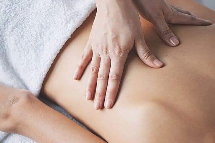 A person receiving a massage with hands on their back. 2