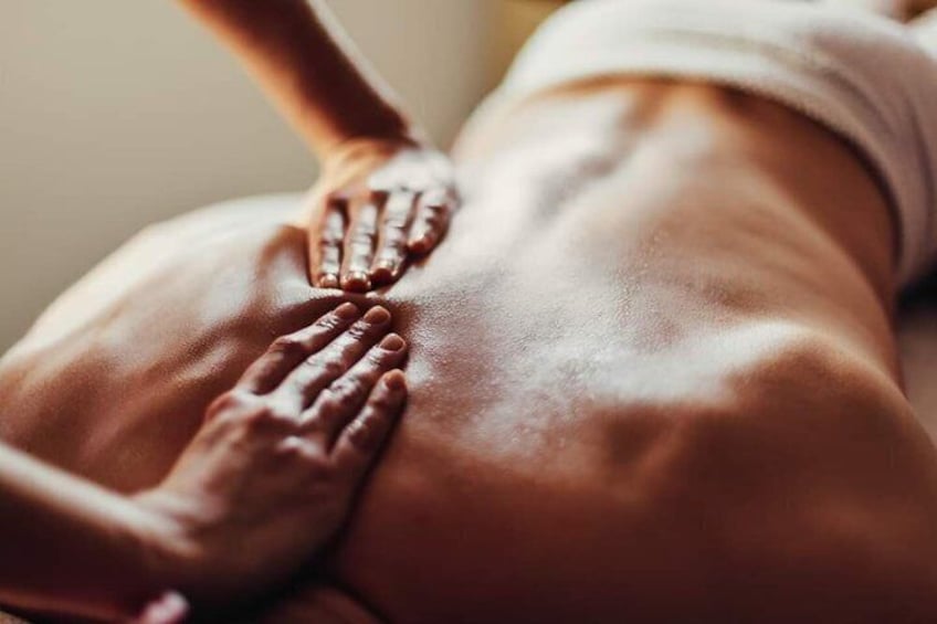 A close-up of a person's back with hands applying pressure. 5