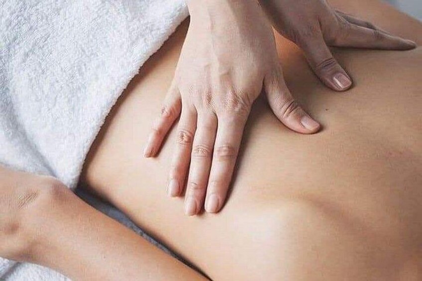 A close-up of hands performing a massage on a person's back. 2