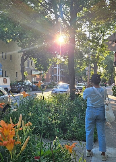 A person standing on a sidewalk, a tree, and a building with a sign. 4