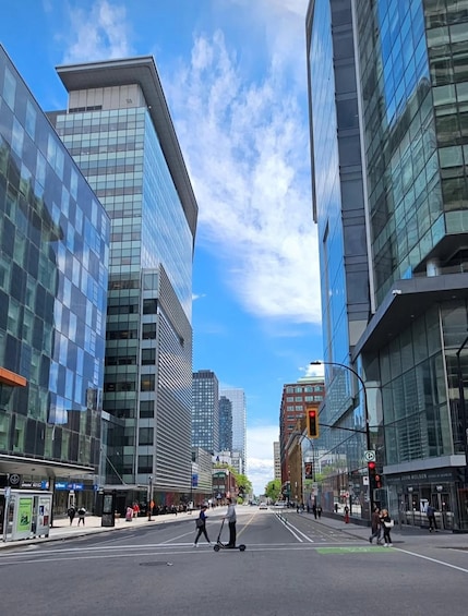 A city street with modern buildings, a pedestrian crossing, and a traffic light. 5