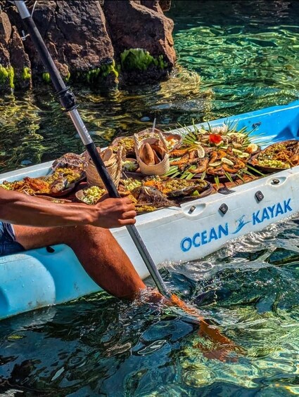 A person paddling a kayak with a seafood feast on board. 4
