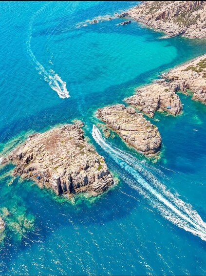 A coastal landscape with rocky formations and clear turquoise waters. 1