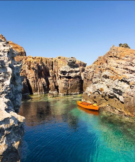 A clear blue water body surrounded by rocky cliffs. 5
