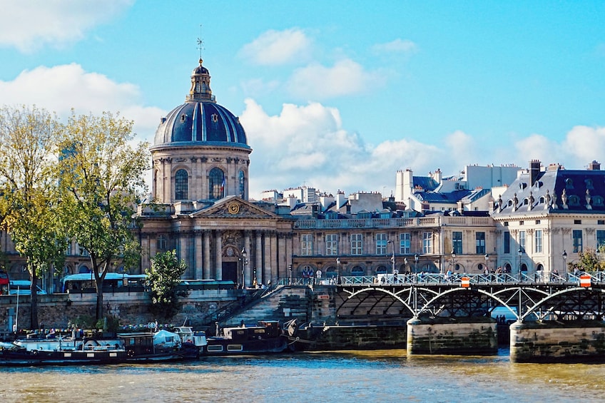 A historic building with a dome, a bridge, and a river. 5