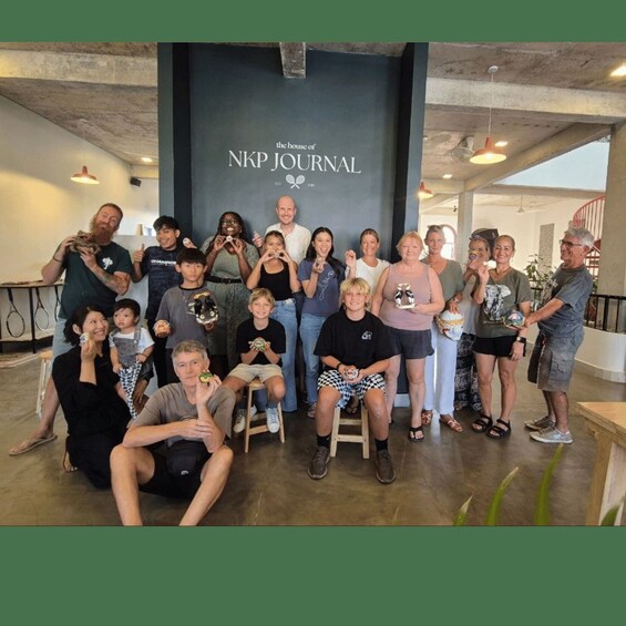 A group of people posing in front of a sign that reads 'the house of NPK Journal.' 1