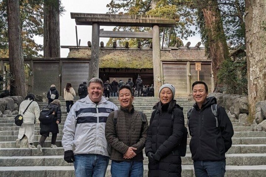 A group of people standing on stone steps with a traditional Japanese structure in the background. 5
