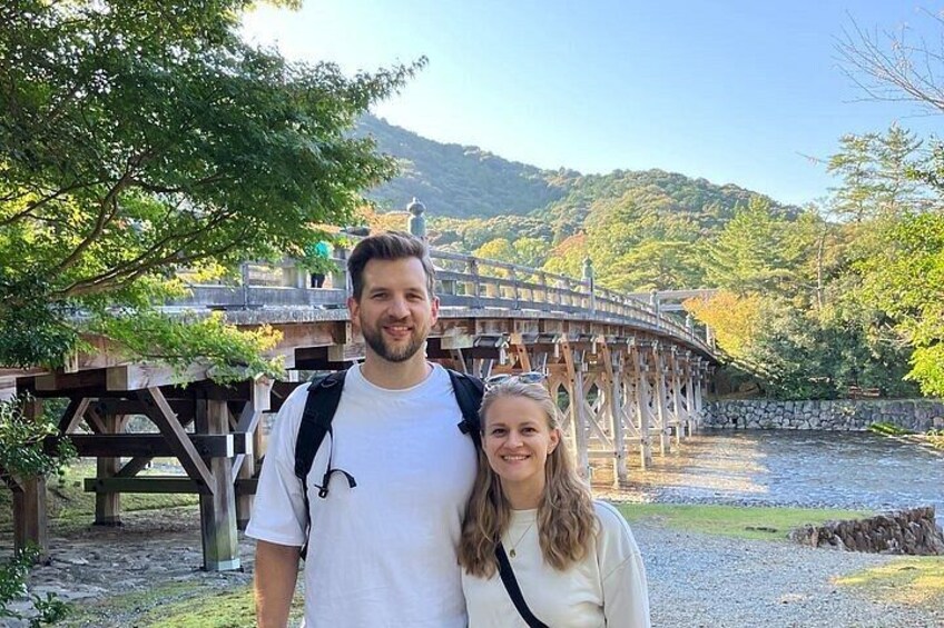 A wooden bridge over a river with a mountainous backdrop. 2