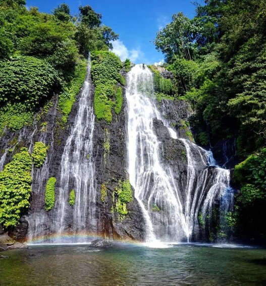 Een meerlaagse waterval, omringd door weelderige begroeiing. 4