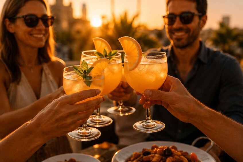 A sunset with people toasting with drinks garnished with orange slices and mint leaves. 5