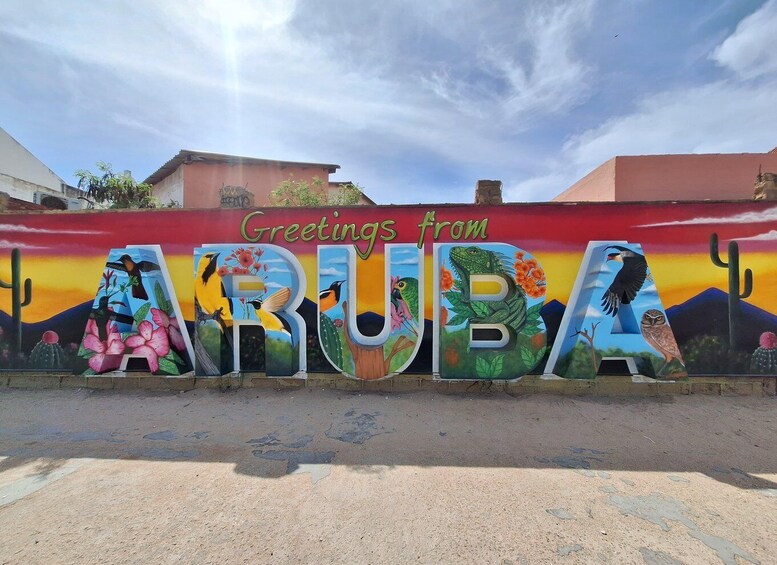 A colorful mural with the word 'ARUBA' and a desert landscape. 1