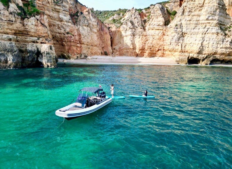 A boat anchored near a rocky coastline with clear turquoise water. 5