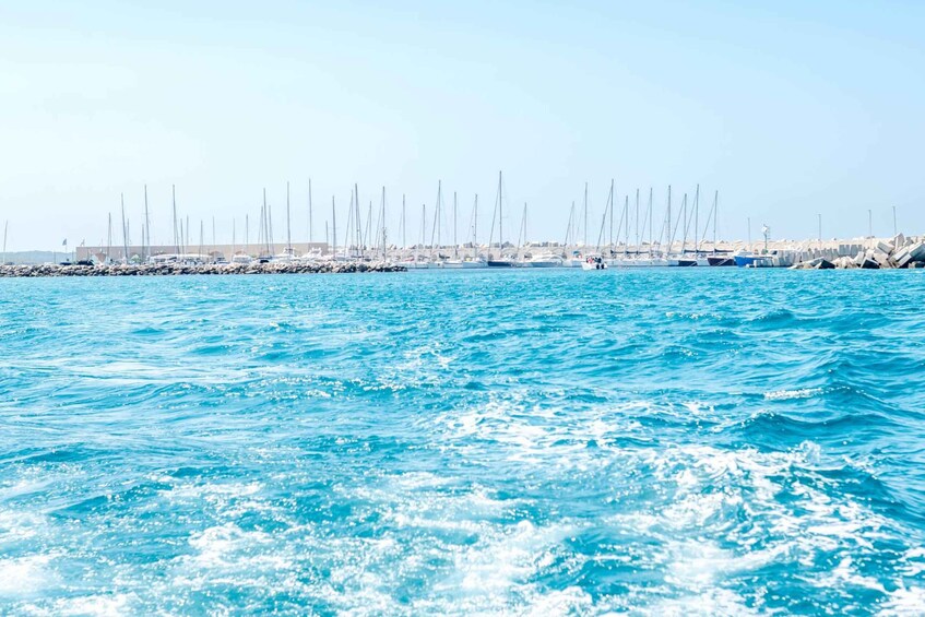A marina with sailboats docked along a rocky shoreline. 5