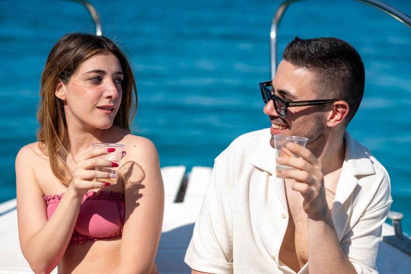 Two people on a boat with a blue water background. 1