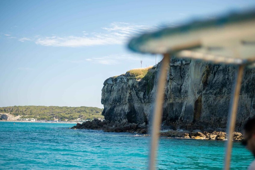 A coastal cliff with a clear view of the sea and distant land. 4