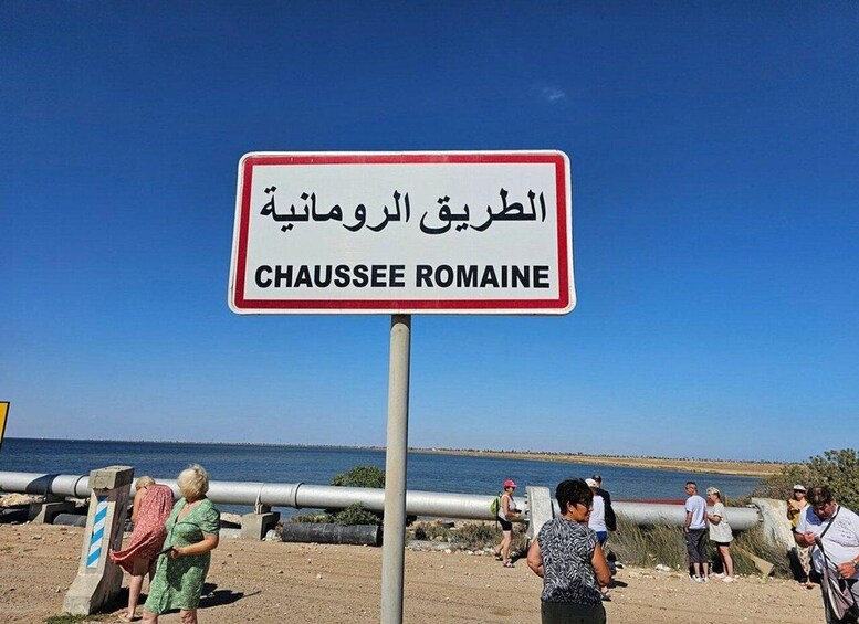 A sign with 'CHAUSSEE ROMAINE' written in both Arabic and English, indicating a location. 2