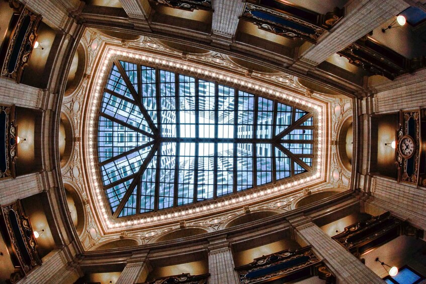 An ornate ceiling with a large skylight and intricate architectural details. 1
