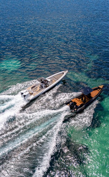 Two boats on a clear blue sea with visible underwater terrain. 5
