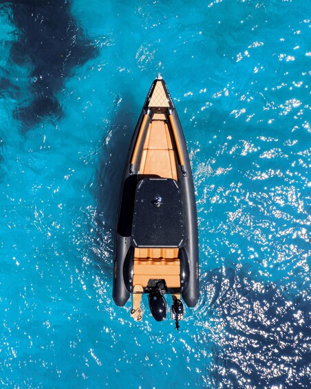 A small inflatable boat on clear blue water. 1