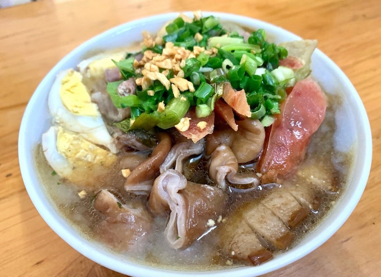 A bowl of soup with various ingredients like meat, vegetables, and a boiled egg. 3