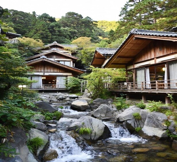 A traditional Japanese ryokan with a koi pond and a waterfall. 1