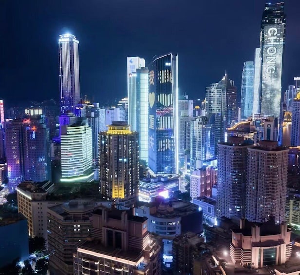 A cityscape at night with illuminated skyscrapers and a river in the foreground. 2