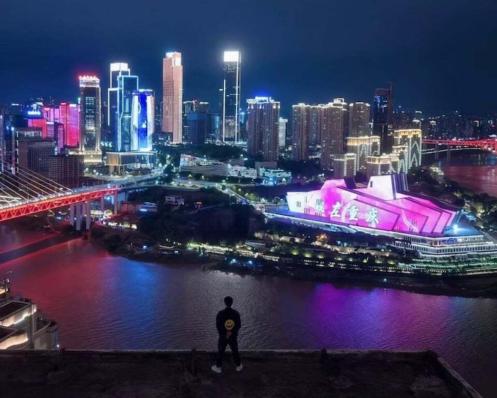 A nighttime cityscape with illuminated buildings and a bridge over a river. 4