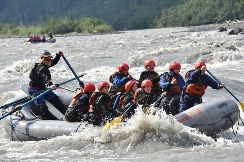 A group of people in a raft navigating a river. 4