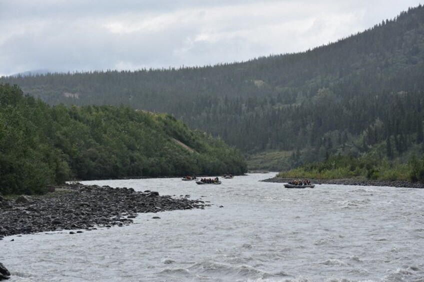 A river with boats, surrounded by forested hills. 4