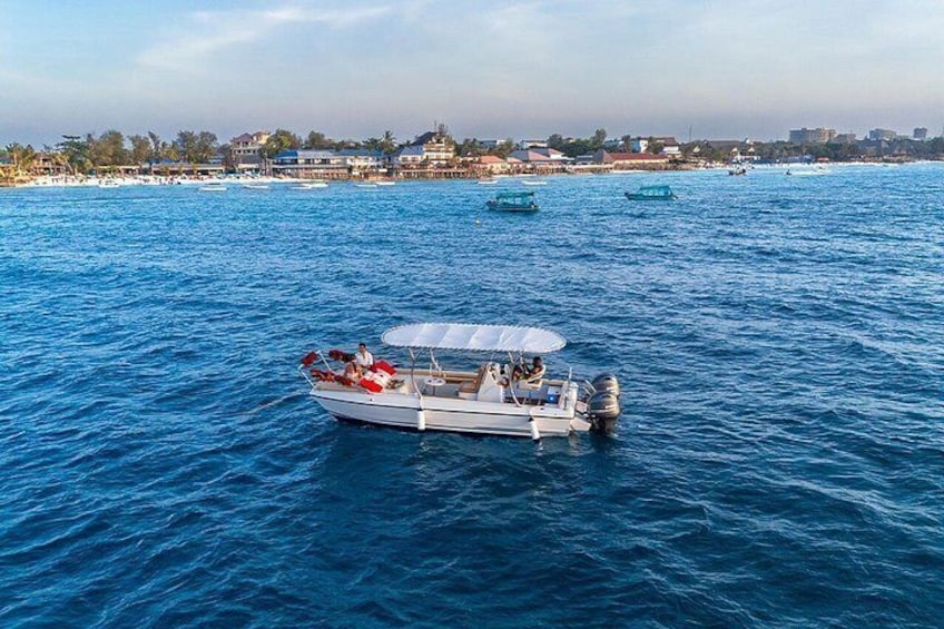 A boat on a blue sea with a cityscape in the background. 3