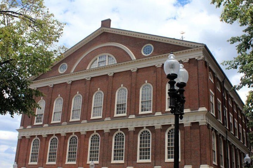 A red brick building with arched windows and a clock tower. 2