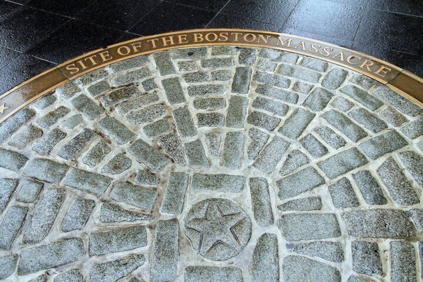 A cobblestone pavement with a star emblem and the inscription 'SITE OF THE BOSTON MASSACRE.' 3