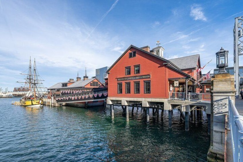 A red building with a sign 'The Old Port' on a waterfront with a ship docked nearby. 1