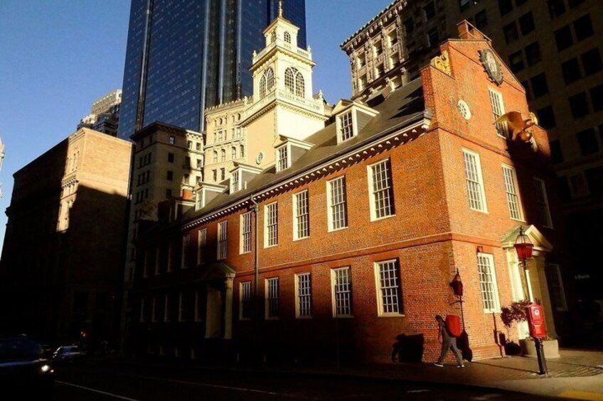 A historic building with a clock tower, surrounded by modern skyscrapers. 4
