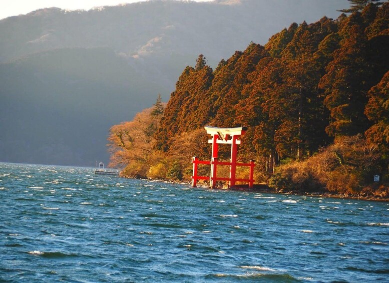 A red torii gate on a lake surrounded by autumn foliage. 5