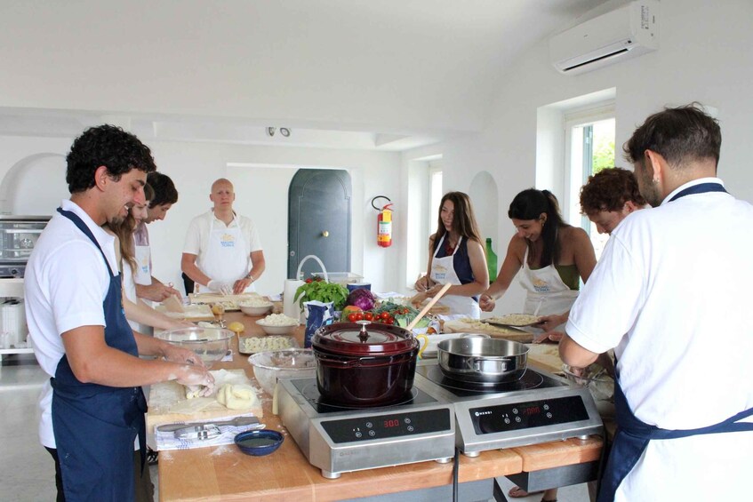 A group of people in a kitchen preparing food. 3