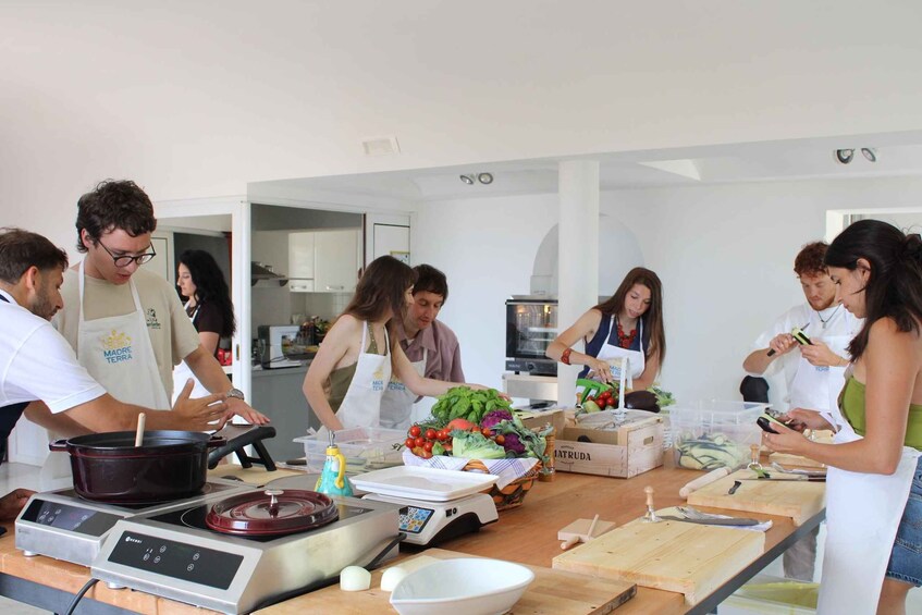 A group of people cooking in a modern kitchen with various cooking equipment and ingredients. 1