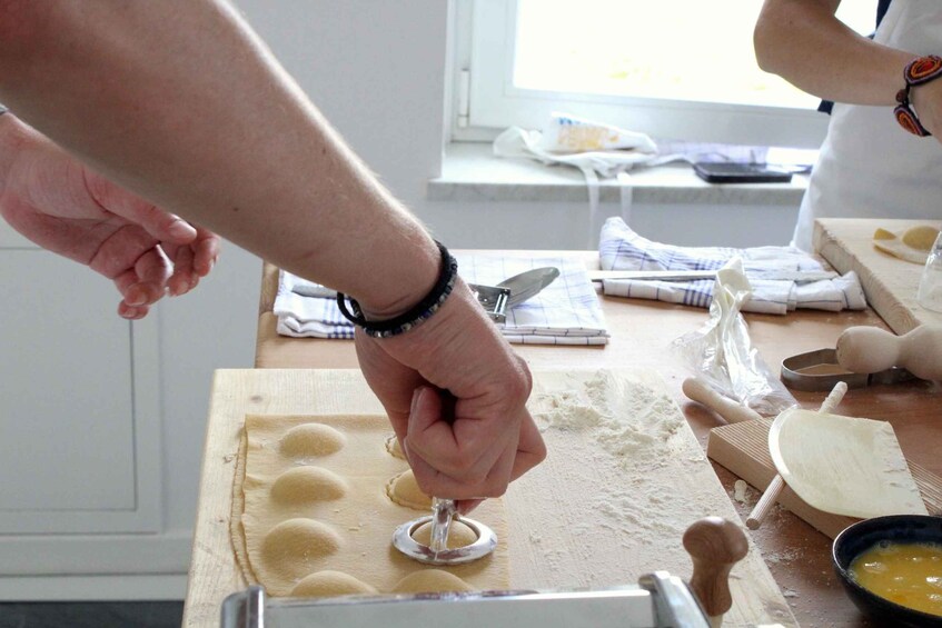 A person using a cookie cutter on dough on a wooden board. 2