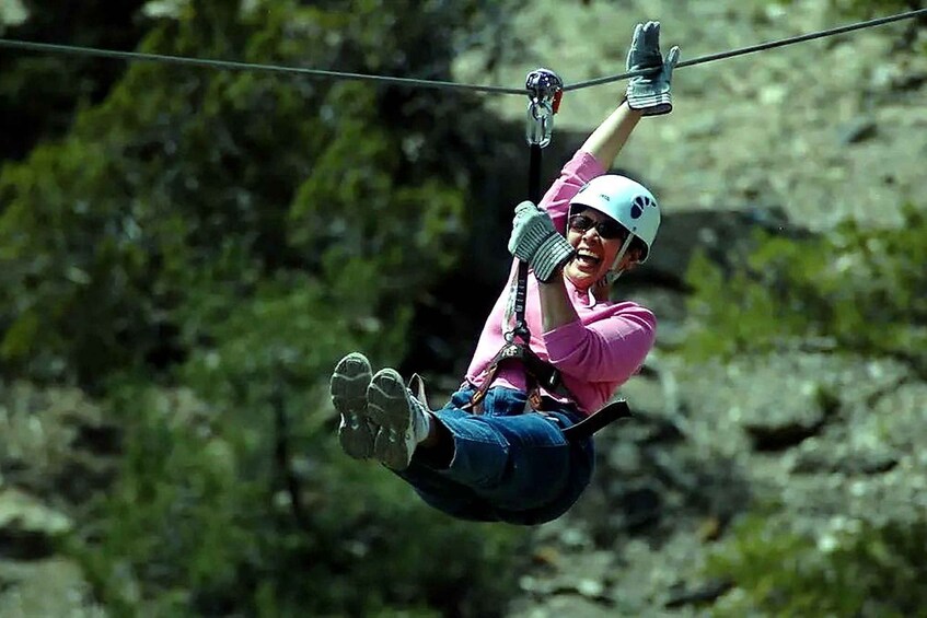 A person zip-lining through a forested area. 3