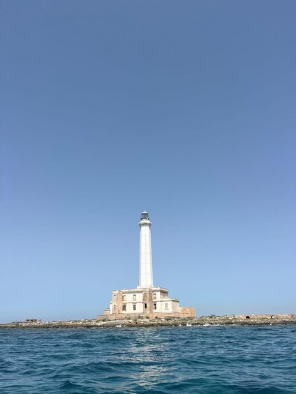 A lighthouse on a rocky outcrop with clear blue skies. 3