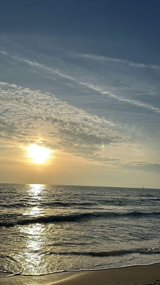 A sunset over the ocean with waves on the shore. 2