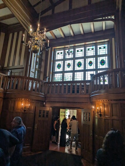 A grand hall with a high ceiling, ornate chandeliers, and stained glass windows. 3