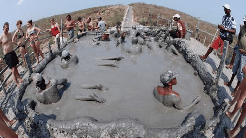 A group of people in a communal bath area with a stone structure. 3