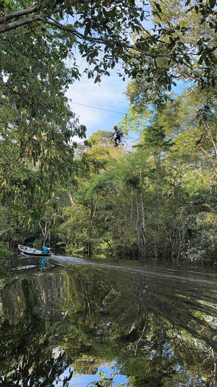 A person riding a bicycle through a forested area with a river in the foreground. 5