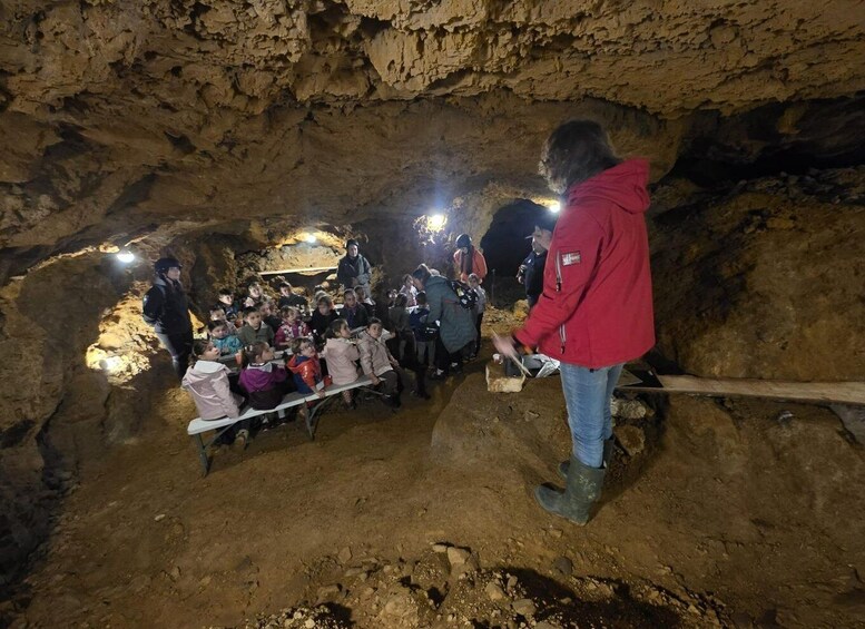 A group of people inside a cave with a guide leading them. 2