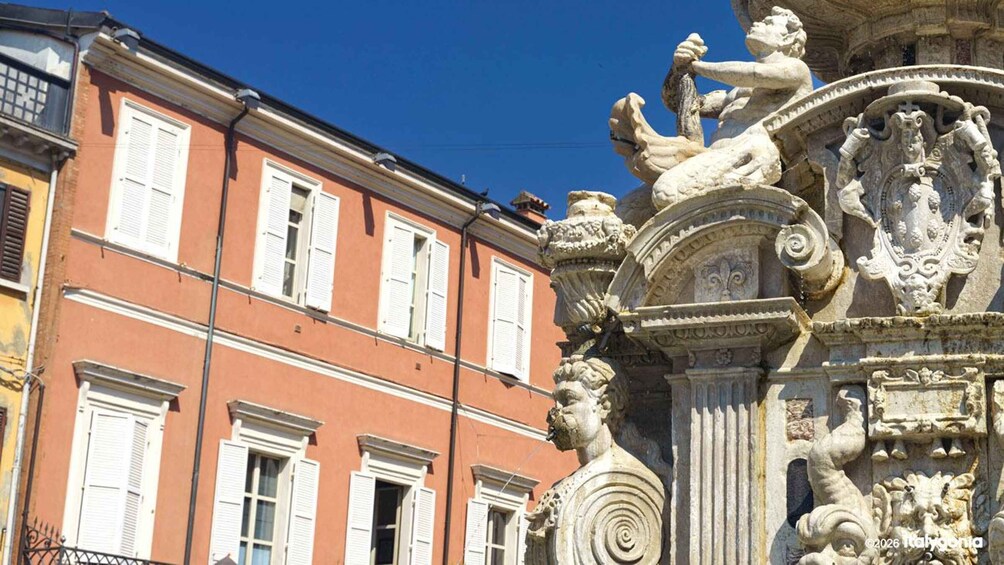 A historic building with ornate stone carvings and a red facade. 2